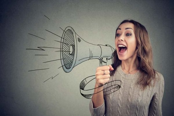 Cheerful woman sharing with news using loudspeaker
