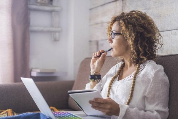 nice woman type on a laptop working at home free and happy. thinking looking outside