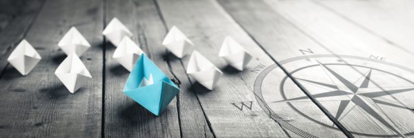 Blue,Paper,Boat,Leading,A,Fleet,Of,Small,White,Boats